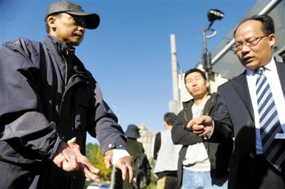 常林鋒在法院外展示雙手，他稱被燙傷的手因刑訊逼供且未得到及時救治