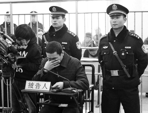 庭審中,29歲的李軍低著頭。