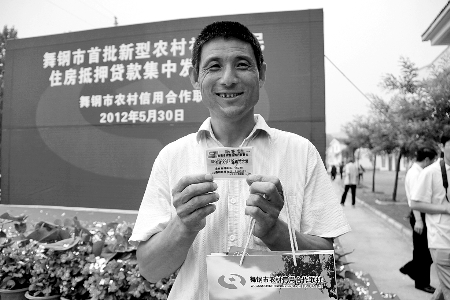領(lǐng)到貸款，農(nóng)民開心地笑了。