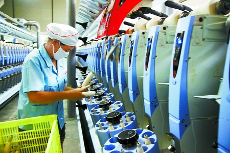 7月3日，在鄧州市永泰棉紡有限公司電腦控制全自動紡紗車間，紡織工人正在生產(chǎn)棉紗。