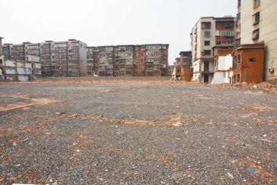 為降塵，旮旯王村拆遷后裸露的地面上鋪了一層石子。