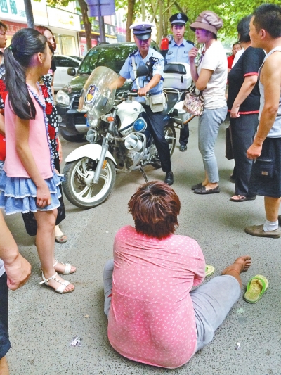 在鄭州優(yōu)勝南路東三街交叉口向東100米處，一名短發(fā)中年女子平躺在路南快車道上，身旁還有一只掉落的拖鞋