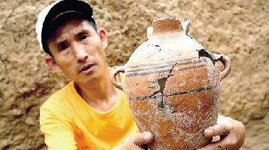 　　考古工作人員展示出土的仰韶文化時(shí)期代表性彩陶。