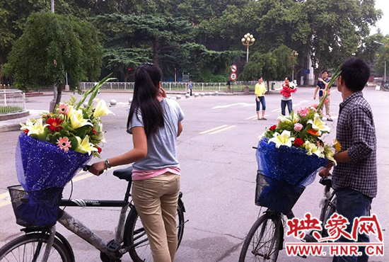 在鄭州大學(xué)南校區(qū)，有不少學(xué)生三五成群，手捧鮮花。