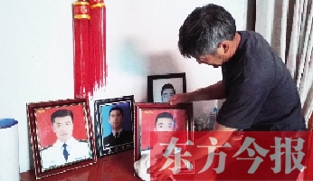 沉浸在悲痛之中的魯有海，擦拭著孩子的遺照