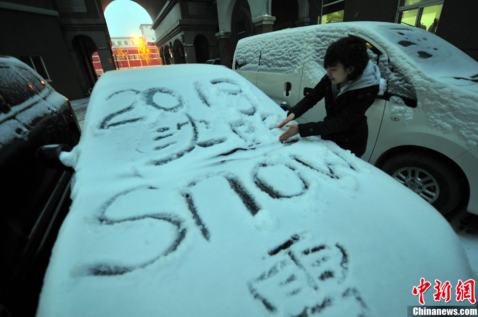 11月18日，行人在車輛的積雪上涂鴉。