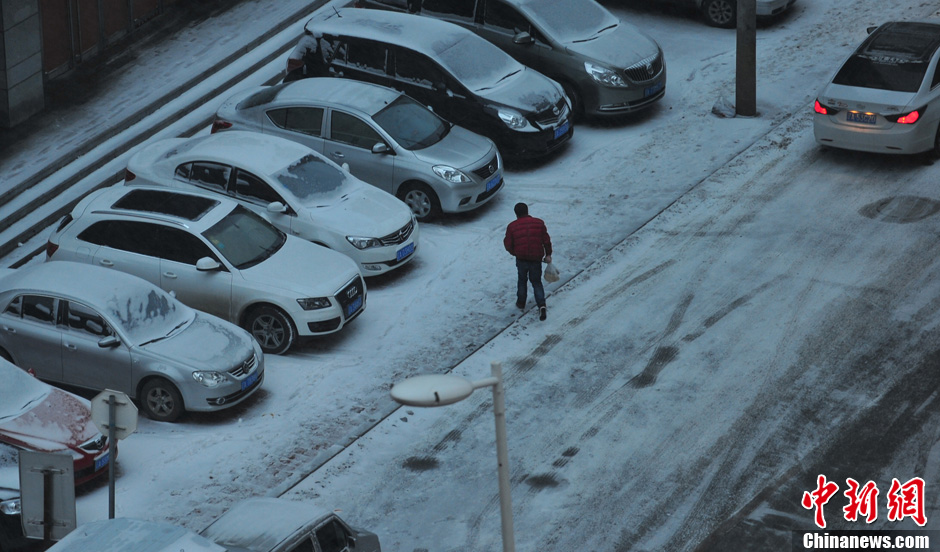 11月18日，行人在沈陽街頭的積雪中穿行。