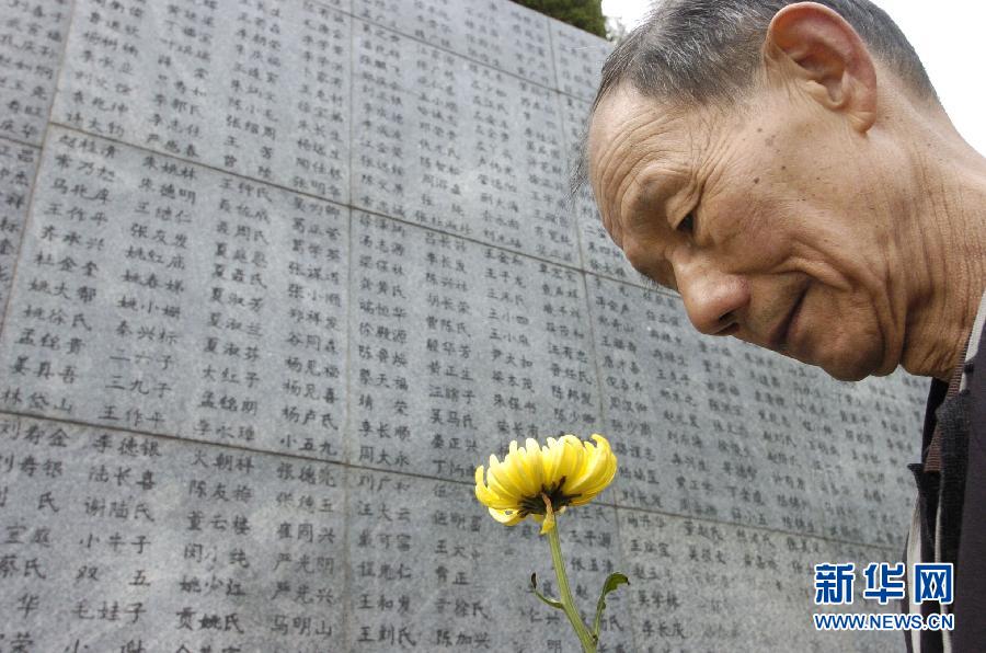 2006年4月5日，74歲的南京大屠殺幸存者佘子清手捧鮮花，祭奠被日軍殺害的母親。