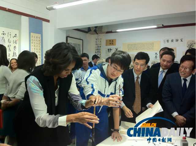 北京時間3月21日，美國第一夫人米歇爾參觀北師大二附中時，與學(xué)生一起練習(xí)書法。
