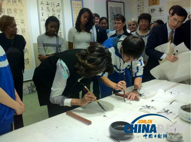 　北京時間3月21日，美國第一夫人米歇爾參觀北師大二附中時，與學(xué)生一起練習(xí)書法。
