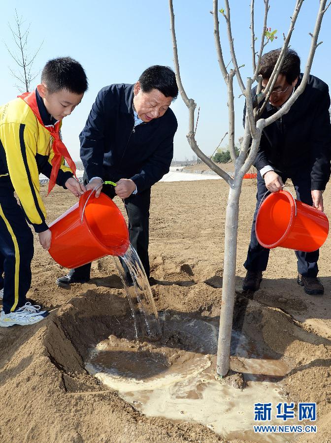 這是習(xí)近平同大家一起給剛栽下的樹(shù)苗澆水。