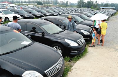昨日，市民在山東棗莊一家拍賣公司場(chǎng)地上查看待拍賣公車。當(dāng)日，棗莊市103輛公車公開拍賣。新華社記者