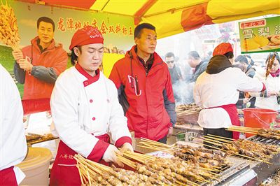 賣羊肉串?dāng)偽焕习遐w山（穿紅衣者）。新京報(bào)記者