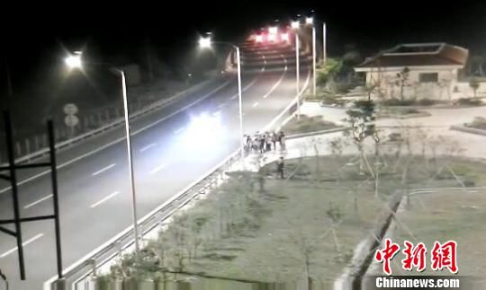 看到車輛經(jīng)過，孩子們便急忙跑到一旁的花圃上?！【焦﹫D　攝