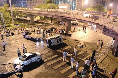 路虎沖下國(guó)貿(mào)橋砸中一輛起亞轎車，橋上厚達(dá)幾十厘米的水泥護(hù)欄被撞斷，碎石四處散落，數(shù)十群眾在現(xiàn)場(chǎng)圍觀。