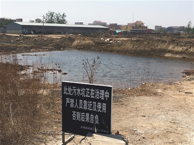 化肥廠滲坑的三分之一經(jīng)過治理，但水質(zhì)仍然呈黃褐色。