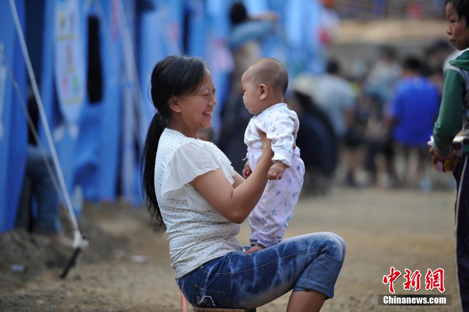 8月6日，一名年輕的母親在和孩子玩樂。
