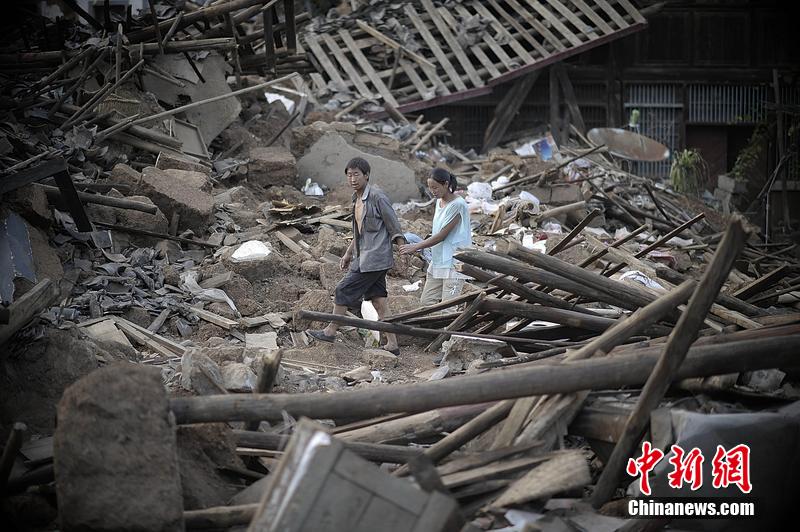 2014年8月5日，云南昭通龍頭山鎮(zhèn)老街，一對夫妻從居住房屋的廢墟中走過。