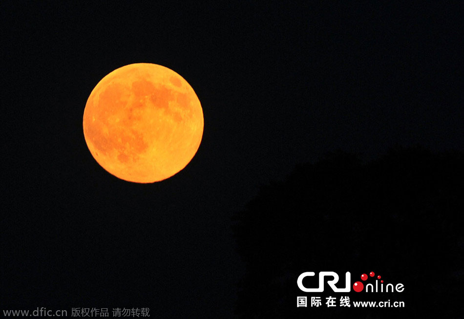 8月10日晚，一輪金燦燦的大月亮在遼寧省大連市東方升起。圖片來(lái)源：劉德斌/東方IC