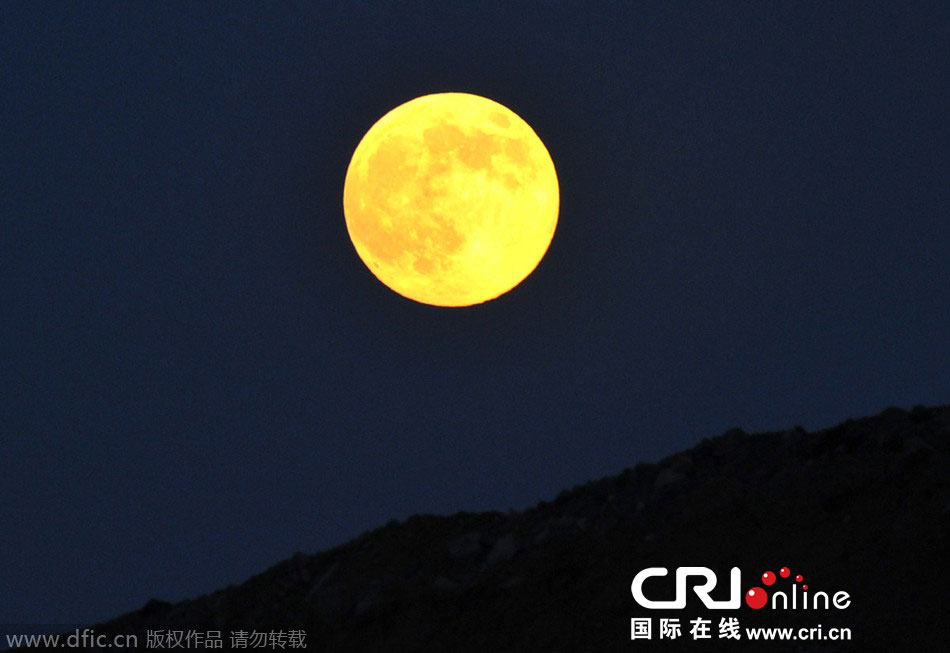 8月10日晚，一輪金燦燦的大月亮在遼寧省大連市東方升起。圖片來(lái)源：劉德斌/東方IC