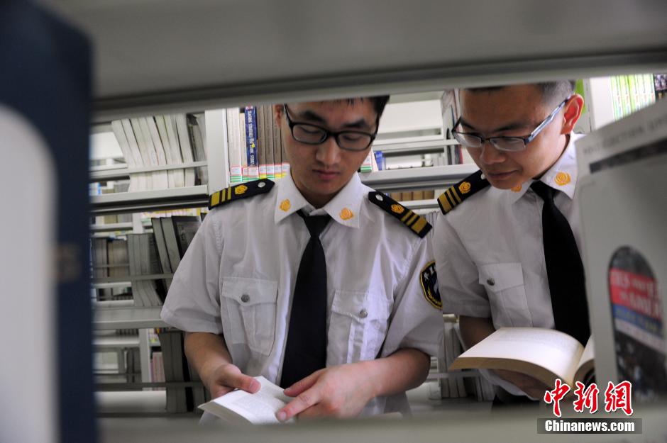 5月8日，武漢輕工大學(xué)圖書館保安吳濤與江力在圖書館交流學(xué)習(xí)。