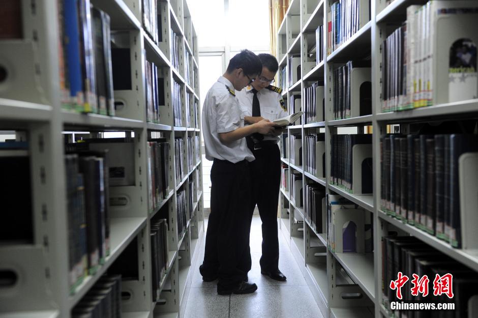 5月8日，武漢輕工大學(xué)保安吳濤與江力在圖書館交流學(xué)習(xí)。中新社發(fā) 張暢 攝