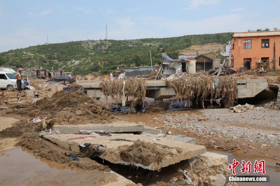圖為洪水過后，坍塌的橋梁上遺落大量雜草。