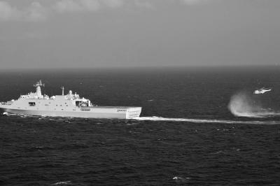 11日，抵達馬航飛機失聯(lián)海區(qū)的海軍井岡山艦與艦載直升機協(xié)同展開立體搜救行動。新華社發(fā)