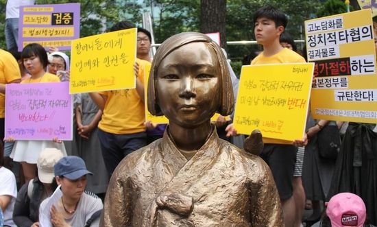 7月2日，在韓國首爾的日本駐韓國大使館前，民眾在慰安婦少女像旁手持標(biāo)語參加抗議活動。