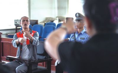 張志國(guó)在法庭上用手語(yǔ)回答提問(wèn)。記者 蒲東峰攝