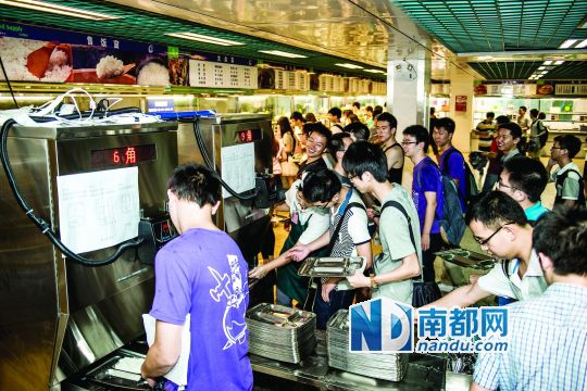 昨日，華南理工大學(xué)一食堂內(nèi)，學(xué)生們正在使用新安裝的自動打飯機(jī)打飯。中新社發(fā)