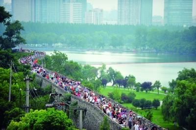 　　昨天,數(shù)萬南京市民參加“環(huán)城七十里”徒步走,圖為解放門城墻上密集的人群。 本版攝影 實習生 王甜