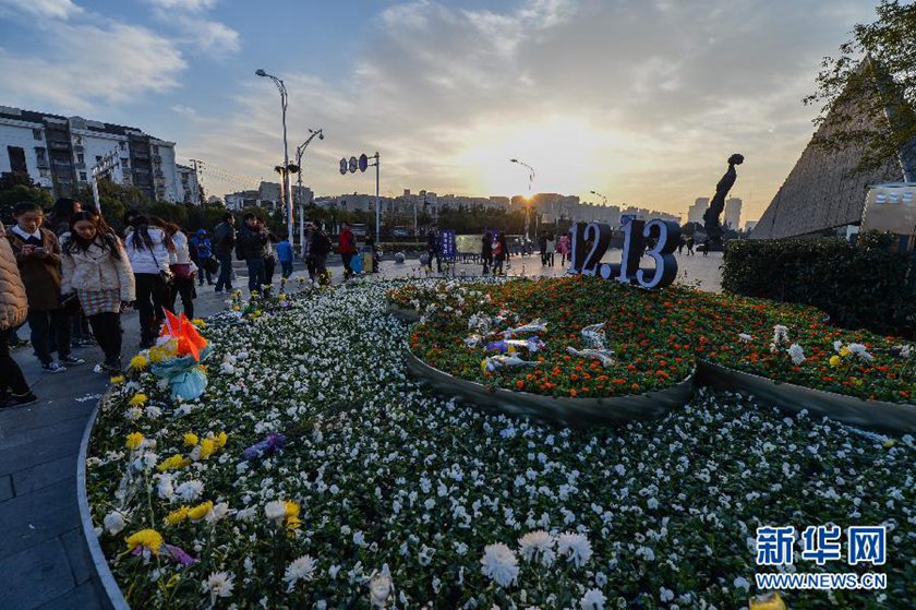 12月14日,觀眾在侵華日軍南京大屠殺遇難同胞紀(jì)念館前的“12·13”花壇上擺放鮮花祭奠遇難同胞。新華社記者 沈鵬 攝