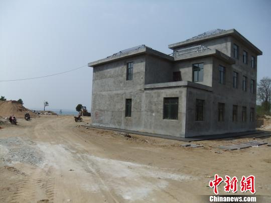 鴨河水庫庫區(qū)邊的新建別墅，一面墻上寫著“拆”，另一邊在加緊施工。吳揚　攝
