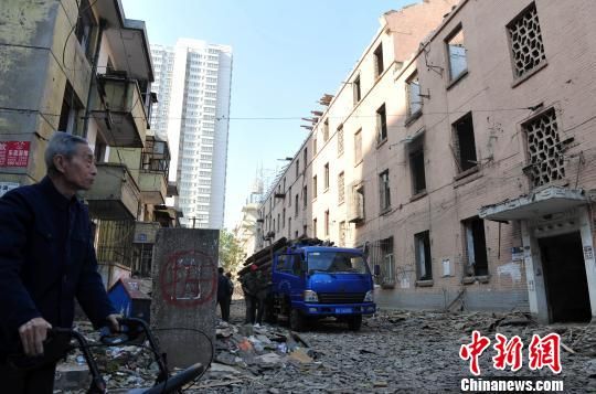一位花甲老人站在即將拆除的樓房旁，默默地與“蘇聯(lián)樓”告別。　翟羽佳　攝