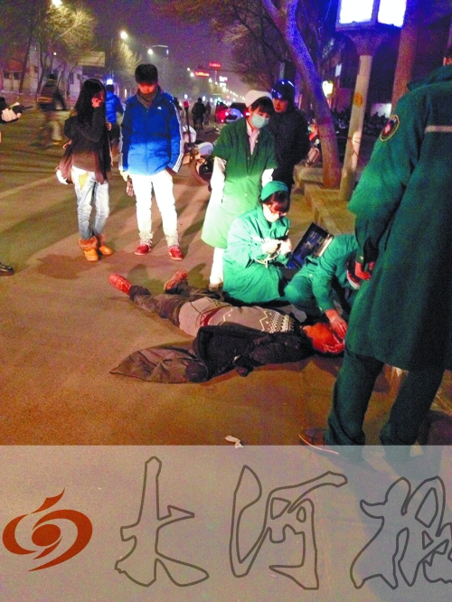 醉漢躺在地上，醫(yī)護人員對其進行檢查。